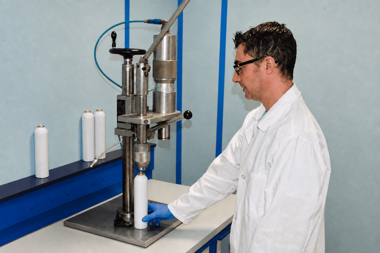 Technicien du LEREM contrôlant un contenant métallique avec des gants de laboratoire